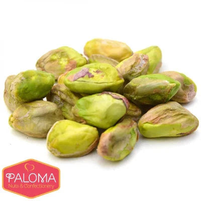A pile of shelled pistachio nuts with green and yellow hues.